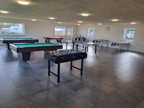 a room with several ping pong tables and chairs at Nakskov Fjord Camping & Cottages in Nakskov