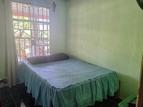 a bed sitting in a room with a window at POSADA VERDE 