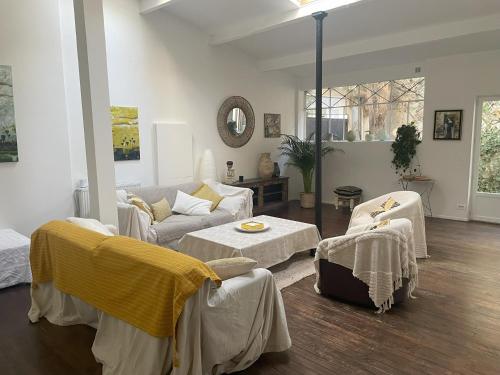 un salon avec un canapé et une table dans l'établissement Artist's Home - Villa & Private Courtyard - 200m2, à Paris