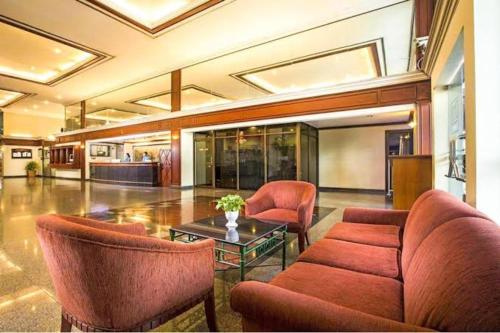a lobby with a couch and chairs and a table at Affordable Serviced Apartments in Nana Omni Tower - Prime Sukhumvit location in Bangkok