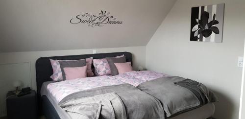 a bedroom with a bed with pink and gray sheets at Ferienwohnung Südharz in Walkenried