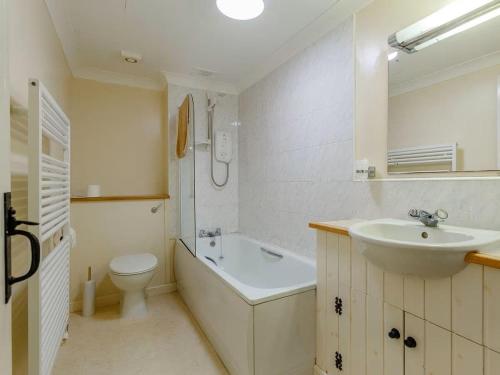 a bathroom with a sink and a toilet and a bath tub at Craiglea Barn in Latheron