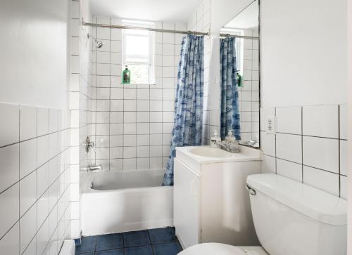 a bathroom with a toilet and a tub and a sink at Appartement 1 chambre 1 lit queen-1009 in Montreal