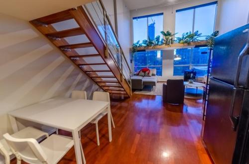 una oficina con escalera, mesa y sillas en loft in downtown Vancouver with free parking en Vancouver