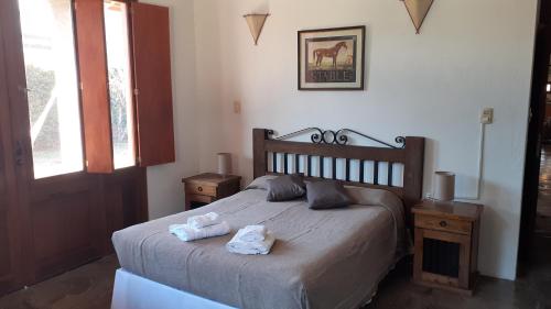 1 dormitorio con 1 cama con 2 toallas en Posada Fresnos Dorados en Maipú