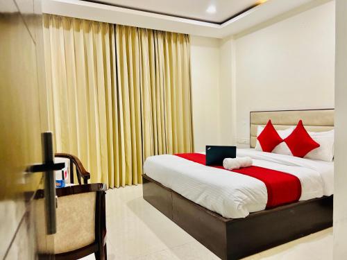 a bedroom with a large bed with red pillows at Hotel The Lycoris - A Corporate and couple friendly hotel in Chandīgarh