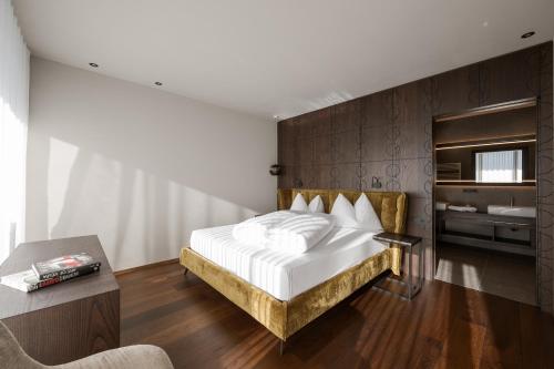Schlafzimmer mit einem weißen Bett und Holzboden in der Unterkunft Feel good Resort Johannis in Dorf Tirol