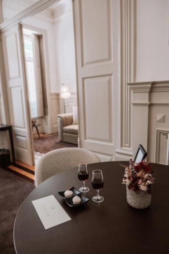 a table with two glasses of wine and flowers on it at Marquês Garden House by Olivia in Porto