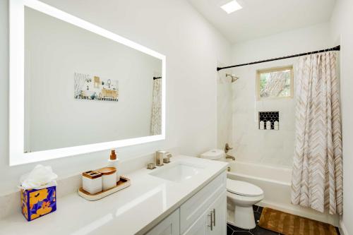 a white bathroom with a sink and a toilet at Chic and Spacious West Dallas Home Near Downtown! in Dallas