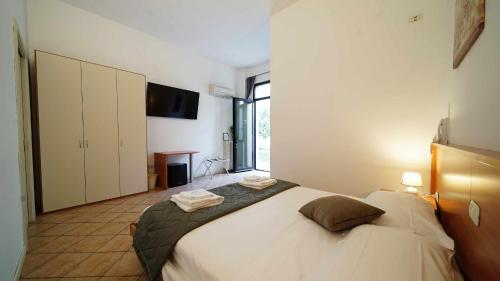 a bedroom with a large bed with towels on it at Destiny rooms valpolicella in Pedemonte