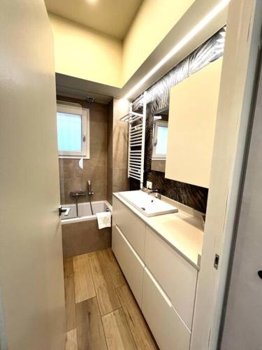 ein kleines Bad mit einem Waschbecken und einem Spiegel in der Unterkunft Home Donatella in Cormano