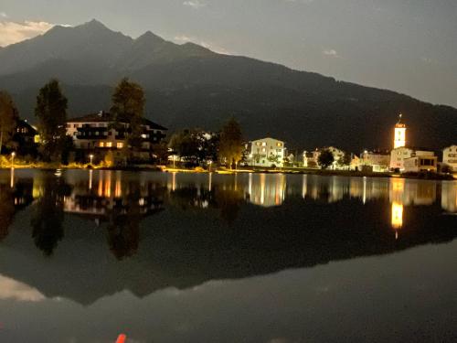a view of a city and a lake at night at Lakeside - 3.5 Zimmer Ferienwohnung am Laaxersee in Laax