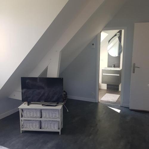 Cette chambre dispose d'un escalier et d'une télévision sur une table. dans l'établissement chambre Elisa Entre Caen et la mer avec piscine, à Mathieu