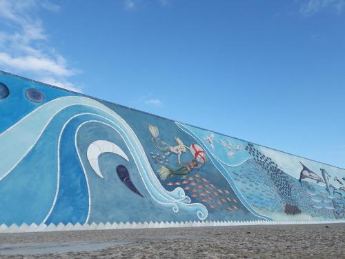 a wall with a painting of a wave at Le Residenze Blu Sardinia in La Caletta