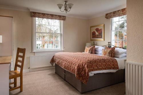 a bedroom with a bed and two windows at Springfield House - Birmingham Airport & NEC in Coleshill