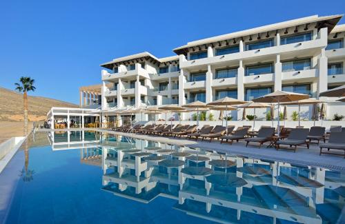 a hotel with a swimming pool with chairs and umbrellas at INNSiDE by Meliá Fuerteventura – Adults Only in Costa Calma