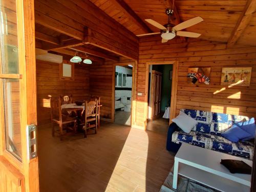 una sala de estar de una cabaña de madera con ventilador de techo en Casa Rural en Yeguada Vistabella., en Enguera