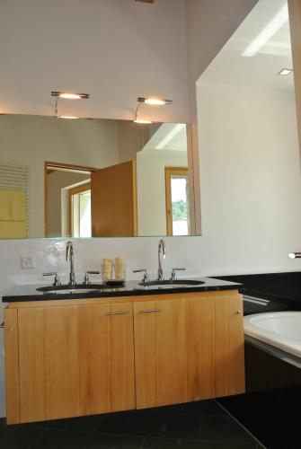 a bathroom with two sinks and a large mirror at Chesa La Montanella - Ferienwohnung, Maloja in Maloja