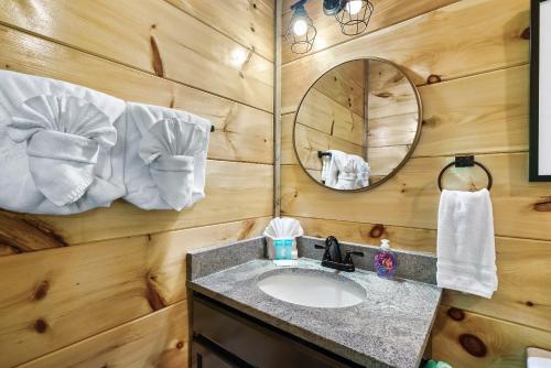 uma casa de banho com um lavatório e um espelho em Modern Pool Cabin, Hot Tub, Pet Friendly, Secluded, Mins to Wilderness em Sevierville
