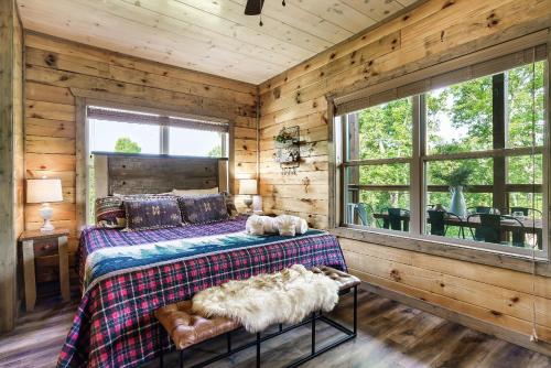 um quarto com uma cama com dois cães deitados sobre ela em Modern Pool Cabin, Hot Tub, Pet Friendly, Secluded, Mins to Wilderness em Sevierville