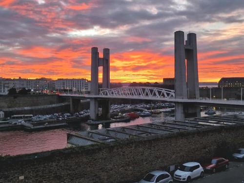 un pont sur une étendue d'eau avec un coucher de soleil dans l'établissement Appartement jolie vue / proche rue de Siam, à Brest