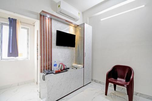 a room with a chair and a tv on a wall at Flagship Diamond Regency Near Birla Mandir in Kolkata