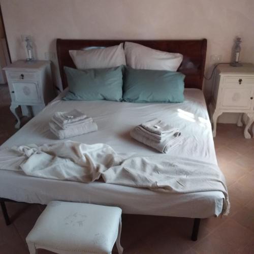a bed with white sheets and pillows on it at B&B Casale Ormano in San Venanzo