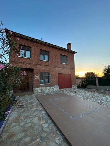 une maison en briques avec un garage et une allée dans l'établissement Casa Rural Alaejos, à Alaejos