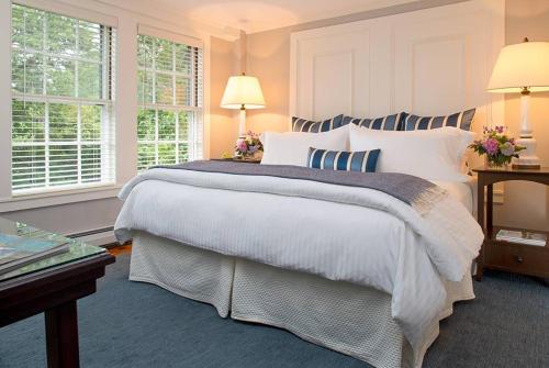 1 dormitorio con 1 cama grande y 2 ventanas en The Inn At English Meadows, en Kennebunk