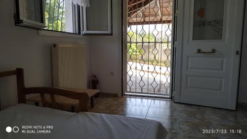 een slaapkamer met een deur naar een patio bij Villa Zeus Thessalonikis in Agia Triada