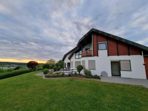 ein Haus mit grünem Rasen davor in der Unterkunft Ferienwohnung Seeblick in Pfullendorf
