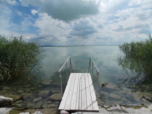 a wooden dock in the middle of a body of water at Zen Garden Resort, Zánka in Zánka