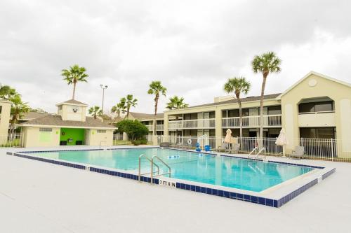 a pool at a resort with palm trees at A & S Vacation Rooms in Kissimmee