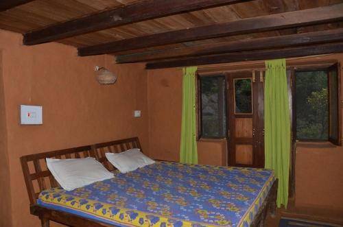 una camera con letto e piumone blu di Shivanandi River Lodge a Rudraprayāg