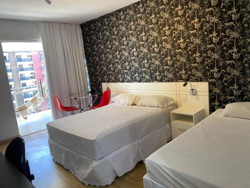 two beds in a hotel room with black and white wallpaper at Garvey Park Hotel in Brasilia