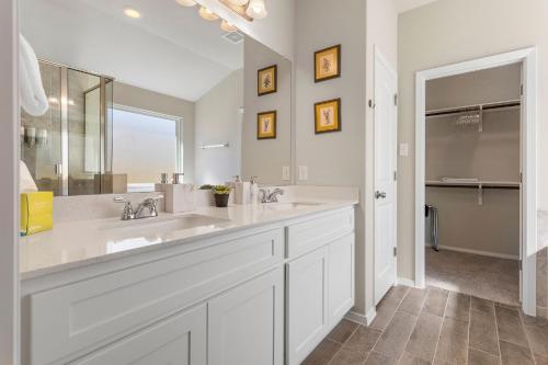 a bathroom with two sinks and a large mirror at Brand New Lake Travis by Barcle in Leander