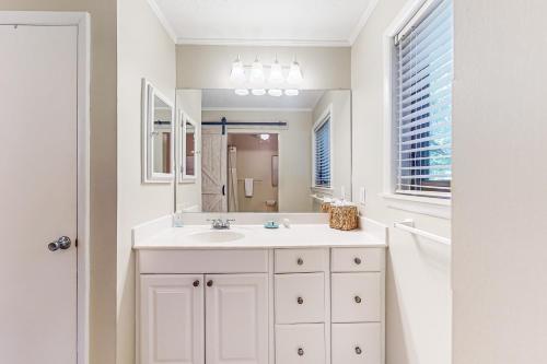 a white bathroom with a sink and a mirror at High Hammock 171 in Seabrook Island