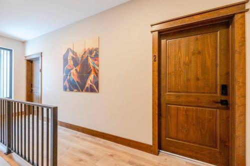 a hallway with a wooden door and a painting on the wall at 22 Sunniva by FantasticStay in Fernie