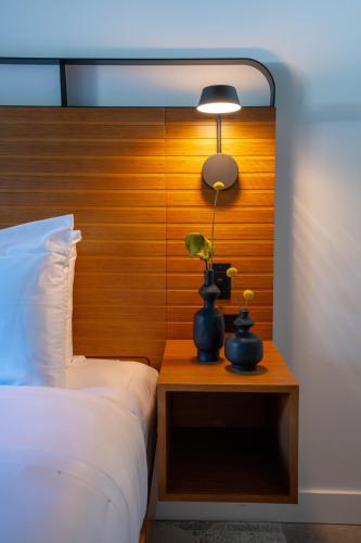 a bed with a wooden headboard and a lamp on a table at The Myriad Hotel Louisville, Tapestry Collection by Hilton in Louisville