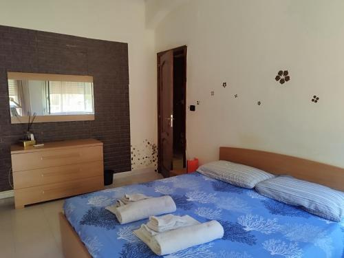 Un dormitorio con una cama azul con toallas. en La casa di Titty en Villa San Giovanni
