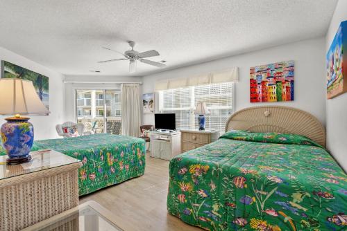 1 dormitorio con 2 camas y TV. en Shorehaven 16B, en Myrtle Beach