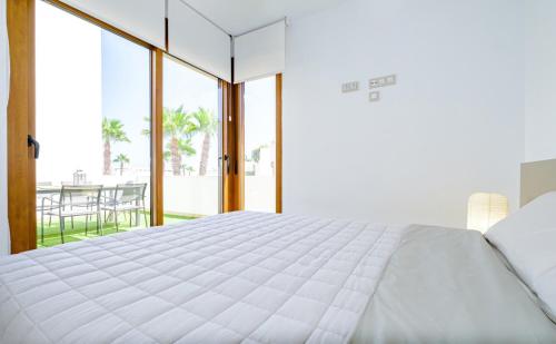 sypialnia z dużym białym łóżkiem i balkonem w obiekcie Secreto De La Zenia ID200 w mieście Playa Flamenca
