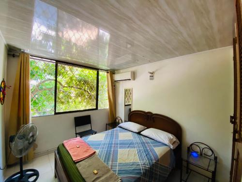 a small bedroom with a bed and a window at Casa Feliz Hostal in Santa Marta