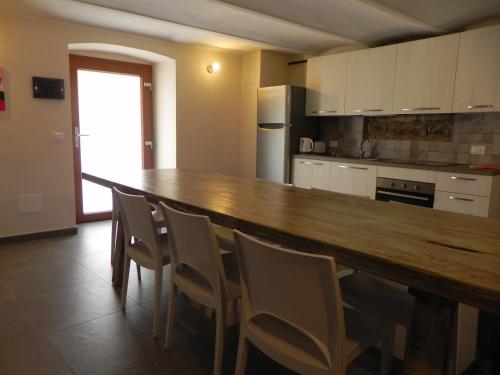 una cocina con una barra de madera larga y sillas en Villa Borgo degli Artisti Exclusive, en Aulla