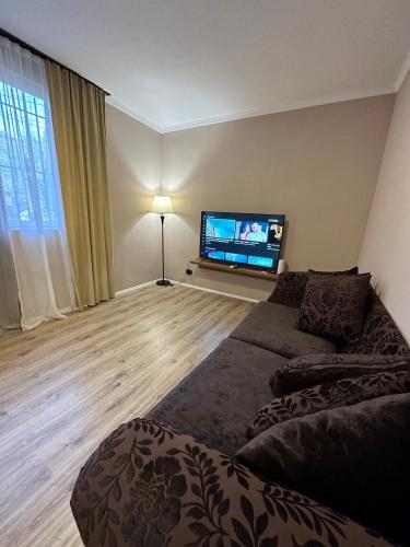 a living room with a couch and a flat screen tv at Bejart Apartment 5 in Tirana