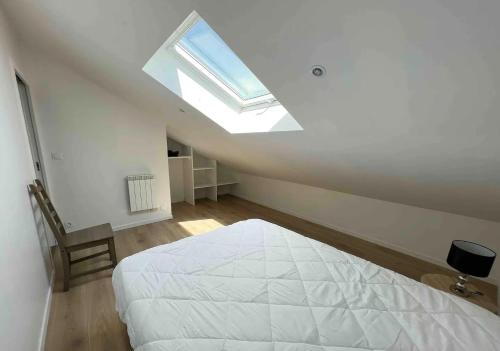 a white bedroom with a bed and a skylight at Maison hyper centre 3 chambres in Fouras