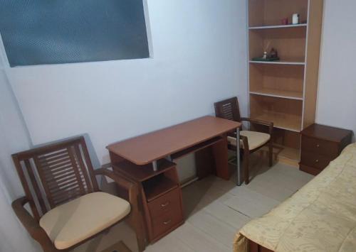 a desk and chairs in a room with a bed at Private Bedroom Paphos Central in Paphos