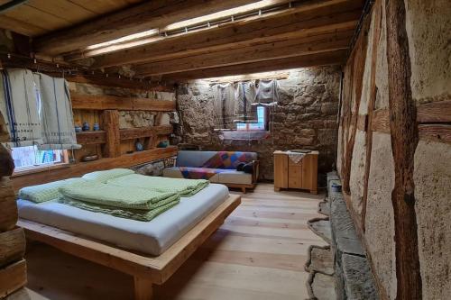 a bedroom with a bed and a couch in a room at Wohnen im Denkmal. Erholung pur. in Sulz am Neckar