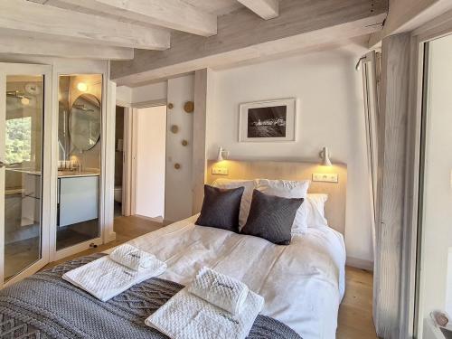 una camera da letto con un grande letto bianco con due cuscini di Chalet au pied des pistes avec sauna, cheminée, parking couvert et Wifi - Saint Martin de Belleville - FR-1-344-1012 a Saint-Martin-de-Belleville