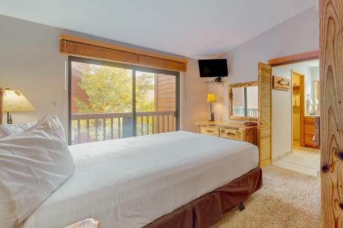 Un dormitorio con una gran cama blanca y una ventana en Pine Ridge 05E, en Breckenridge